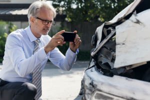 Insurance Adjuster photographing carwreck