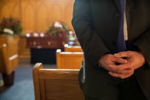 man praying at funeral