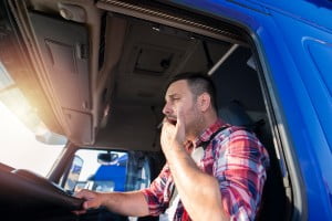 truck driver in front seat yawning