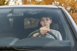 teenager with hand on steering wheel