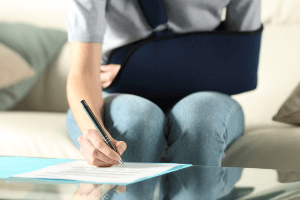 Woman with arm brace signing a document