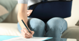 Woman with arm brace signing a document