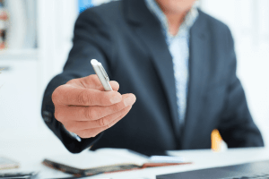 man offering pen for signature