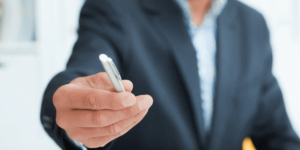 man offering pen for signature