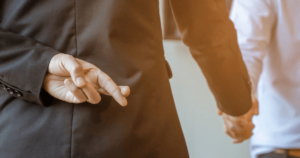 man with fingers crossed behind back