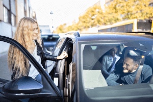 woman getting into a car with other people