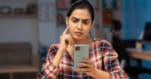 woman staring at her phone hesitantly