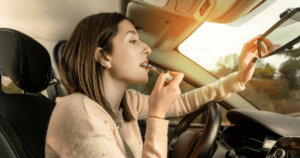 woman putting on her make-up in the car while driving.
