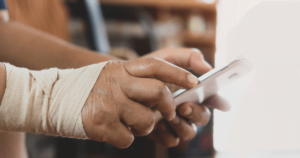 A person with bandaged hands making a phone call.
