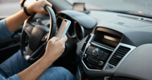 Man texting on a phone while driving.