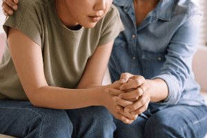 Woman being comforted by a friend.