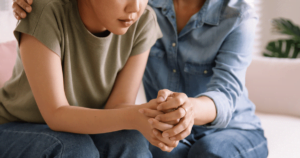 Woman being comforted by a friend.