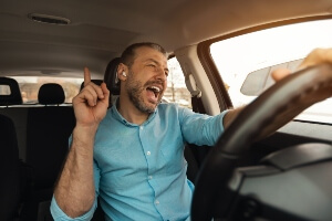 Male driver wearing headphones and singing