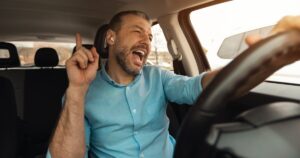 Male driver wearing headphones and singing