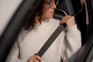 person putting on seat belt