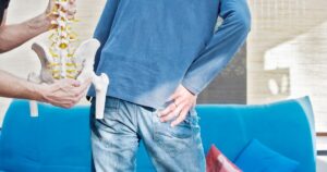 man holding hip in pain