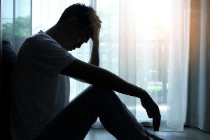 man looking depressed in the dark