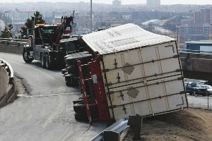 A semi-truck tilted to the side on a road. 