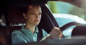Young, attractive white female looking focused while driving