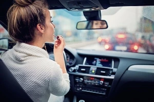 girl putting on makeup while driving