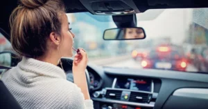 girl putting on makeup while driving