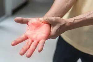 close up of person holding hand in pain