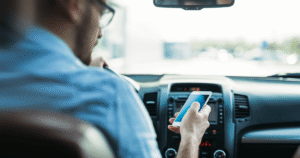 distracted male driver looking at phone