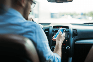 distracted male driver looking at phone