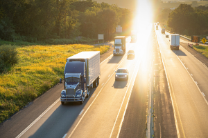 semi-truck and passenger cars driving on a multi-lane highway